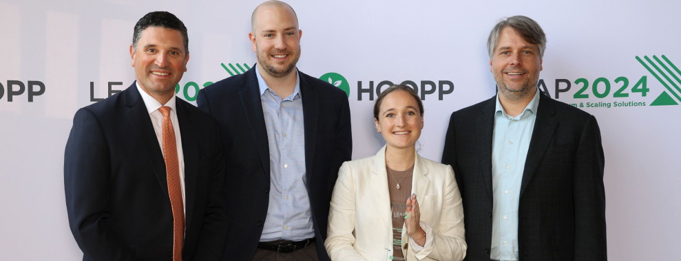 Four individuals standing in a row holding the LEAP award
