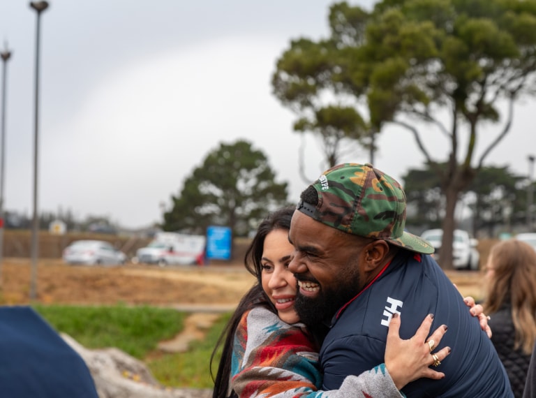 Two people hugging in an outdoor setting